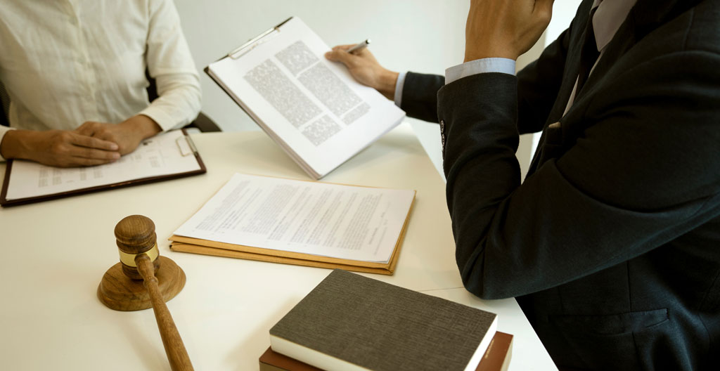 Élu CSE concentré devant son écran d'ordinateur affichant des articles du Code du travail, main sur la souris, bureau moderne épuré, éclairage naturel latéral